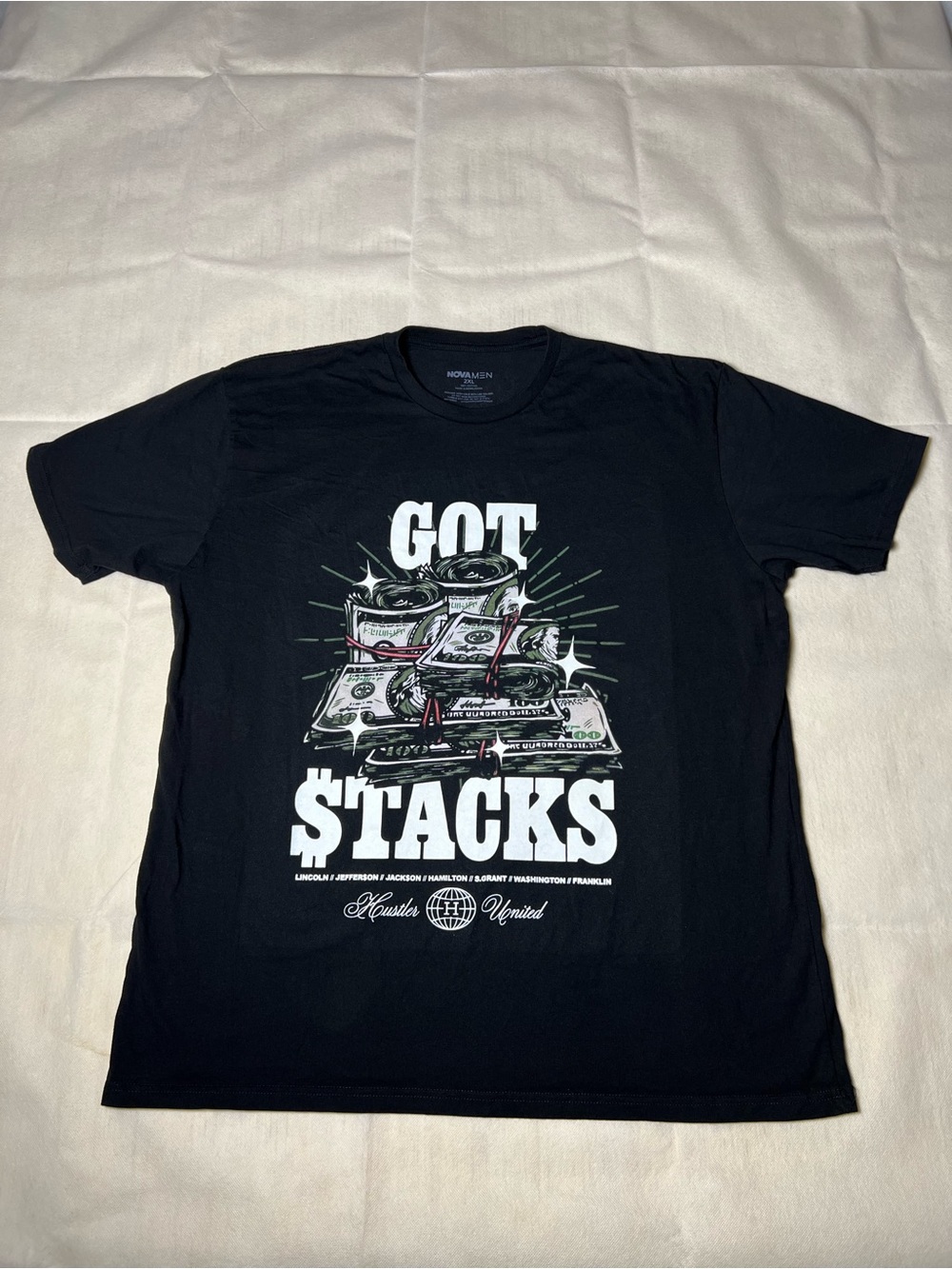 Black cotton graphic tee with white graphic of a stack of money